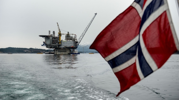 A Norwegian national flag flies from the back of a boat in view of the the Aasta Hansteen gas platform operated by Statoil ASA during its ceremonial baptism near Stord, Norway, on Thursday, March 8, 2018. Oil companies operating in Norway raised investment forecasts for this year after a wave of projects were approved, and expect spending to rise for the first time since crude prices collapsed in 2014. 
