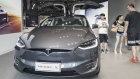 Customers look at a Tesla Motors Inc. Model X electric vehicle on display at the company's showroom in Shanghai. 