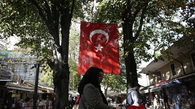 A Turkish national flag hangs between trees in a street lined with shops in Istanbul, Turkey, on Tuesday, Nov. 21, 2017. Investors looking at Turkey are nearly unanimous in their view of the central bank’s latest moves to try and prop up the lira: Not enough. 