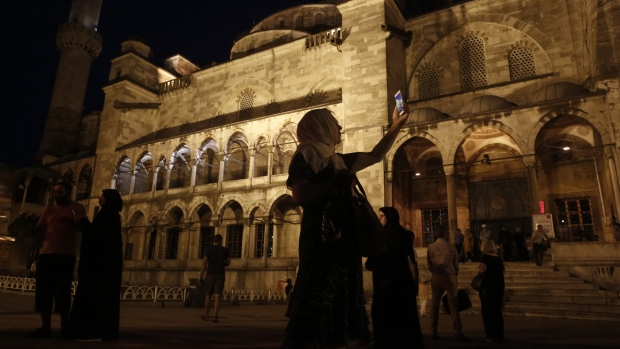 A visitor uses her smartphone to take a photograph at Sultanahmet mosque in the Sultanahmet district of Istanbul, Turkey, on Thursday, Aug. 3, 2017. Turkey’s central bank raised its inflation forecast for this year on higher food prices, and reiterated its policy not to loosen monetary conditions until the outlook improves. 