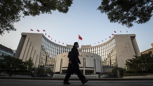 A pedestrian wearing a face mask walks past the People's Bank of China headquarters in Beijing, China, on Monday, Oct. 23, 2017. China's central bank is said to have gauged demand for 63-day reverse repurchase agreements for the first time ever. 