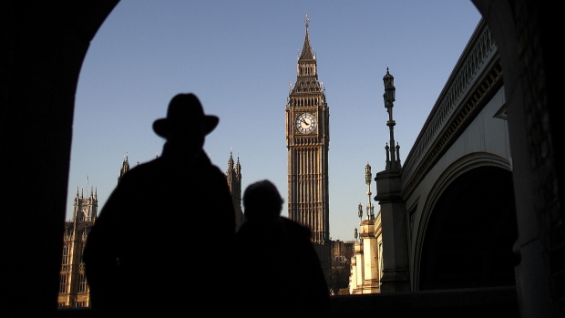 Tourists walk through an arch on the south bank of the River Thames, beside Westminster Bridge, with a view of the Houses of Parliament and Big Ben clock tower in central London, U.K., on Thursday, Dec. 29, 2016. Demand for luxury brands in the U.K. is flourishing, boosted by increased tourism and spending linked to the weaker pound. 