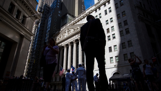 Pedestrians pass in front of the New York Stock Exchange (NYSE) in New York, U.S., on Monday, May 21, 2018. U.S. stocks surged and the dollar strengthened against most major peers and as the Trump Administration sought to deescalate a trade rift with China. 