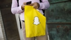 A pedestrian holds a Snap Inc. bag outside of the company's building in the Venice Beach neighborhood of Los Angeles, California, U.S., on Wednesday, Feb. 7, 2018. Snap's first earnings beat as a public company, prompted at least five upgrades from analysts after the social-media company reported fourth-quarter revenue and daily active users ahead of estimates. 
