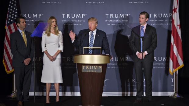 Donald Trump, 2016 Republican presidential nominee, second right, speaks as his sons Eric Trump, right, Donald Trump Jr., left, and his daughter Ivanka Trump listen during the grand opening ceremony of the Trump International Hotel in Washington, D.C., U.S., on Wednesday, Oct. 26, 2016. The Trump Organization has eight hotels in the U.S. and seven in other countries. The Trump International Hotel Washington, D.C. is housed in the 1899 Romanesque Revival-style Old Post Office on Pennsylvania Avenue. 