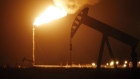 The silhouette of an electric oil pump jack is seen near a flare at night in the oil fields surrounding Midland, Texas, U.S., on Tuesday, Nov. 7, 2017. Nationwide gross oil refinery inputs will rise above 17 million barrels a day before the year ends, according to Energy Aspects, even amid a busy maintenance season and interruptions at plants in the U.S. Gulf of Mexico that were clobbered by Hurricane Harvey in the third quarter. 