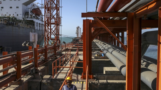 A worker walks along a jetty as a ship sits docked at the Vadinar Refinery complex operated by Nayare Energy Ltd., formerly known as Essar Oil Ltd. and now jointly owned by Rosneft Oil Co. and Trafigura Group Pte., near Vadinar, Gujarat, India, on Wednesday, April 25, 2018. The refinery was the crown jewel in a blockbuster $13 billion acquisition that, at the time, represented the largest foreign direct investment in India's history. The deal marked Trafigura's coming of age. 