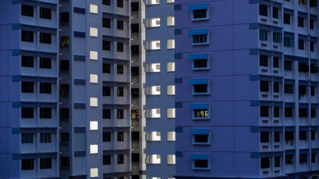 Public housing blocks are illuminated at dusk in the Kallang area of Singapore, on Saturday, Sept. 17, 2016. Singapore is currently mired in its most prolonged housing slump on record. Home prices in the city-state fell for the 11th straight quarter in the three months ending June 30, posting the longest losing streak since records started in 1975. 