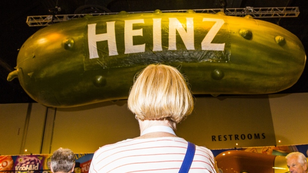 An attendee visits Kraft Heinz Co. booth during a shareholders shopping day ahead of the Berkshire Hathaway annual meeting in Omaha, Nebraska, U.S., on Friday, May 4, 2018. Berkshire Hathaway Inc. investors should get ready for a bumpy ride. Warren Buffett's company is scheduled to report earnings Saturday morning before its annual meeting, and a new accounting rule could sink results. 