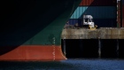 A truck drives past a container ship at the Port of Los Angeles in Los Angeles, California, U.S., on Wednesday, March 28, 2018. Long-only exchange-traded funds (ETFs) linked to broad baskets of energy, metals and agricultural products attracted $2.66 billion this quarter, Bloomberg Intelligence estimates show. While that's the largest quarterly inflow in data going back to 2005, the stream of money slowed in March as the U.S.-China trade row clouded the outlook for economic growth. 