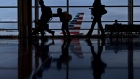 Travelers walk past an American Airlines Group Inc. aircraft at Ronald Reagan National Airport (DCA) in Washington, D.C., U.S.