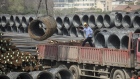 A coil of steel wire is loaded onto a truck at a depot on the outskirts of Shanghai, China