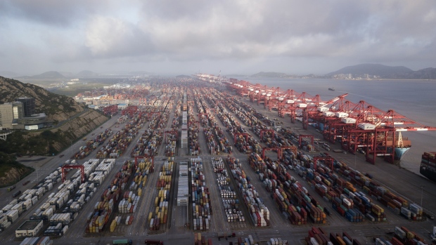 Containers sit stacked next to gantry cranes at the Yangshan Deep Water Port, Shanghai