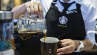 An employee pours coffee from a glass jug into a mug at a Starbucks Corp. coffee shop