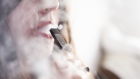 A person smokes a Juul Labs Inc. e-cigarette