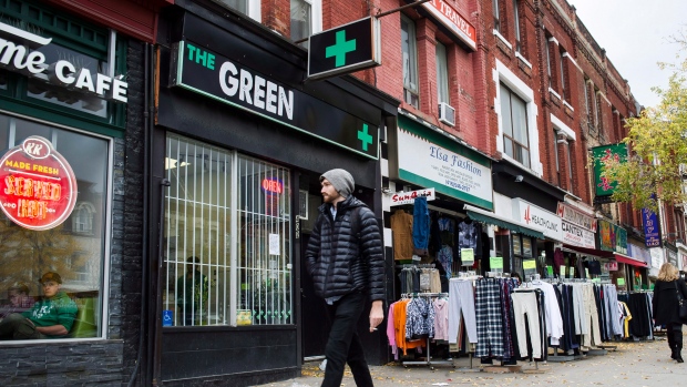 People walk past a cannabis dispensary in Toronto on Monday, October 15, 2018. 