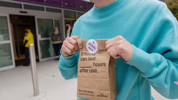 A customer holds a sealed bag containing cannabis products outside of a store in Halifax on Oct. 17. Photographer: Dean Casavechia/Bloomberg