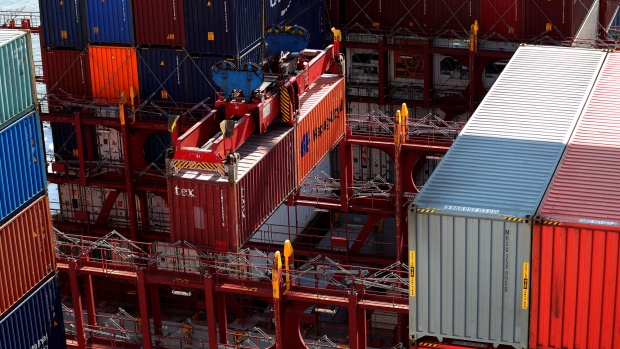 A pair of shipping containers hang from a ship-to-shore crane as container ship Guayaquil Express, operated by Hapag-Lloyd AG, is unloaded at the HLA Container Terminal Altenwerder (CTA) in the port of Hamburg in Hamburg, Germany, on Sunday, Sept. 2, 2018. Container shipping is set for its best third quarter peak season in recent years. 