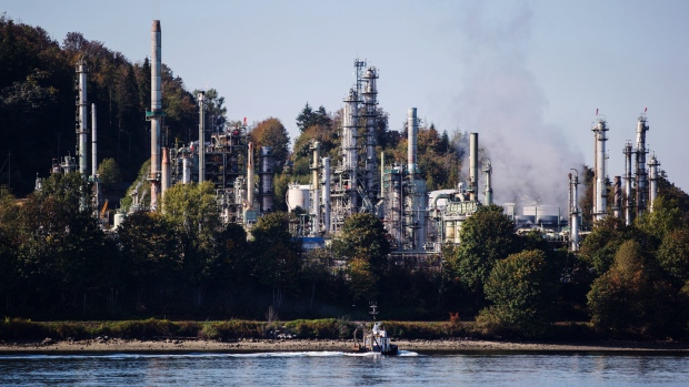 A boat sails past a refinery in Burnaby, British Columbia, Canada. 