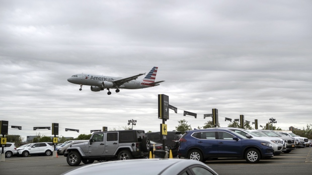An American Airlines Group Inc. plane flies above the Hertz Global Holdings Inc. rental location at LaGuardia Airport (LGA) in the Queens borough of New York, U.S., on Sunday, May, 6, 2018. Hertz Global Holdings Inc. is scheduled to release earnings figures on May 7. 