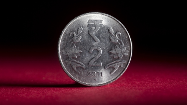 An Indian 2 rupee coin is arranged for a photograph in Bangkok, Thailand, on Wednesday, Sept. 12, 2018. India's rupee dropped to a record low before trimming last week's loss; the government unveiled measures to prop up the sagging currency, including steps to facilitate bond issuance by local companies and possible curbs on imports. 