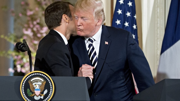 U.S. President Donald Trump, right, embraces Emmanuel Macron, France's president, at a news conference during a state visit in the East Room of the White House in Washington, D.C., U.S., on Tuesday, April 24, 2018. 