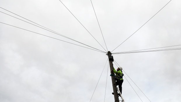 A network engineer from Openreach, a unit of BT Group Plc, climbs a telegraph pole to carry out maintenance work in this arranged photograph in Upminster, U.K., on Thursday, Nov. 10, 2016. Regulator Ofcom called on BT, the U.K.'s former telecommunications monopoly, to set up a legally separate entity for the Openreach network unit within BT, with its own board, but stopped short of seeking a breakup. 