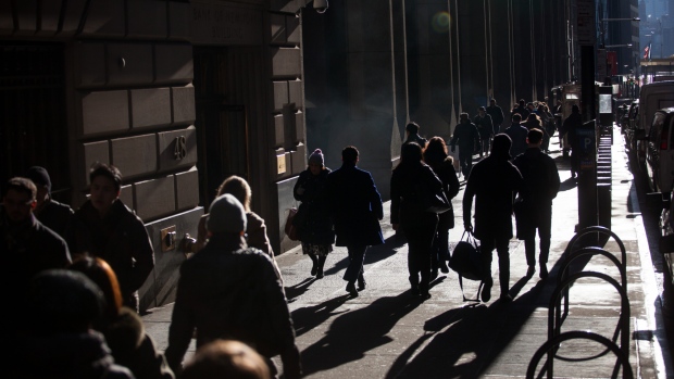 Pedestrians walk along Wall Street near the New York Stock Exchange (NYSE) in New York, U.S. 