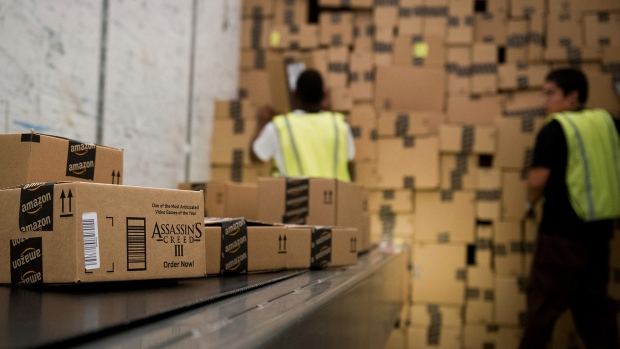 Employees load a truck with boxes to be shipped at the Amazon.com Inc. distribution center in Phoenix, Arizona. 