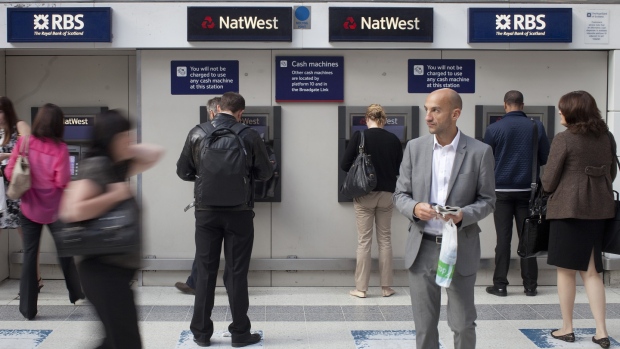 Customers queue to use Royal Bank of Scotland Group Plc (RBS) and NatWest automated teller machines (ATM) on the concourse at Liverpool Street rail station in London, U.K.,