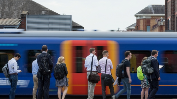 Commuters wait to board a South Western Railway passenger train, operated by Firstgroup Plc, in Guildford, U.K., on Monday, June 11, 2018. FirstGroup Plc, the unprofitable operator of British trains and Greyhound buses that rejected overtures from Apollo Global Management, remains open to bids and has started a broad review of its businesses after Chief Executive Officer Tim O’Toole resigned. 