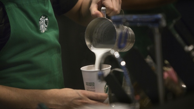 A barista pours frothed milk into a drink inside a Starbucks Corp. coffee shop in New York, U.S., on Monday, Jan. 18, 2016. 