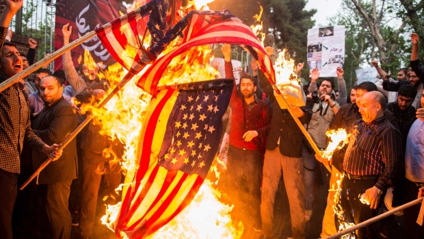 Iranians burn American flags during an anti-U.S. demonstration outside the former U.S. embassy headquarters in Tehran, Iran, on Wednesday, May 9, 2018. U.S. President Donald Trump pulled out of the 2015 deal that put limits on Iran’s nuclear program in exchange for rapprochement with the West.