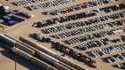 Vehicles sit parked near freight trains in a rail yard in this aerial photograph taken above Toronto, Ontario, Canada, on Monday, Oct. 2, 2017. Canada's trade picture continued to deteriorate in August as exports dropped for a third straight month and the deficit unexpectedly widened. 