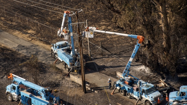 Pacific Gas & Electric Co. (PG&E) employees work to fix downed power lines burned by wildfires in this aerial photograph taken above Santa Rosa, California, U.S., on Thursday, Oct. 12, 2017. Wildfires that tore through northern California's iconic wine-growing regions have prompted evacuations of more than 20,000 people, killed 11 and damaged some of the most valuable vineyards and wineries in the U.S. About 1,500 commercial, residential and industrial structures were burned, and damage assessment teams have started accounting for the destruction. 