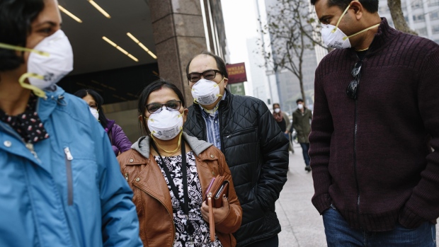 People wear masks while smoke from the Camp Fire fills the air in San Francisco on Nov. 15. Photographer: Michael Short/Bloomberg 