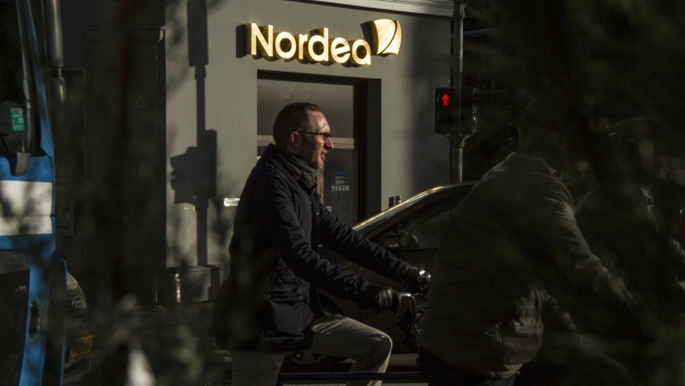 Cyclists wait in traffic near a Nordea Bank AB branch in Copenhagen, Denmark, on Tuesday, Nov. 12, 2013. 