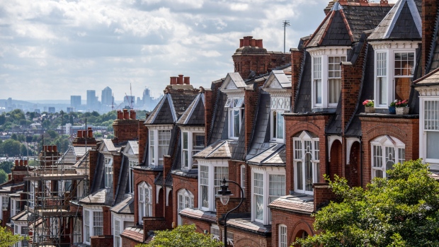 A terraced row of residential housing sit in the Muswell Hill district, in view of the Canary Wharf financial, business and shopping district of London, U.K., on Tuesday, July 31, 2018. U.K. house prices bucked their recent trend with a modest pick up in growth in July, according to Nationwide Building Society. 