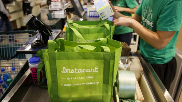 InstaCart employees fulfill orders for delivery at a Whole Foods store in Los Angeles. Photographer: Patrick T. Fallon/Bloomberg