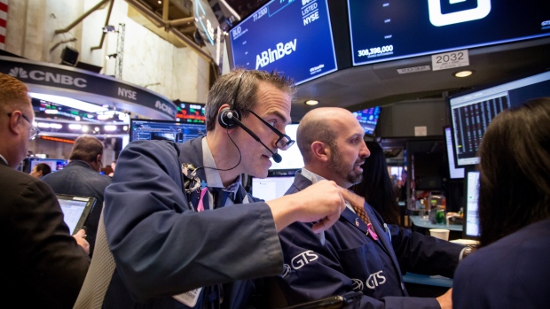 Traders work on the floor of the New York Stock Exchange (NYSE) in New York, U.S., on Friday, Nov. 16, 2018. U.S. equity indexes fluctuated as energy and utility gains were offset by a plunge in retail and technology stocks. 