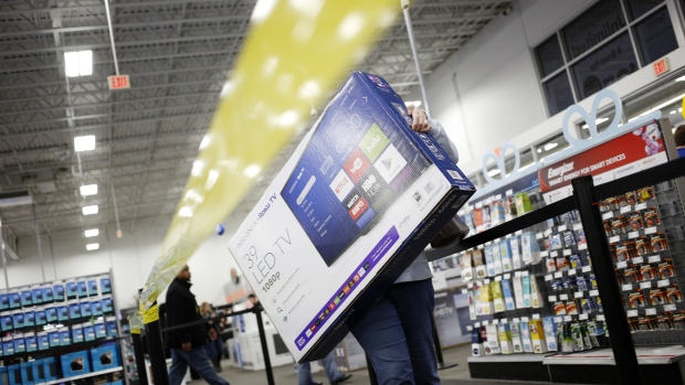 A shopper carries an Insignia Roku TV television at a Best Buy Co. store in Louisville, Kentucky, U.S., on Thursday, Nov. 23, 2017.