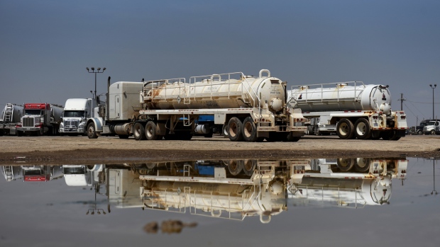 Trucks are seen reflected in a puddle at Love's Travel Stop in Pecos, Texas - Permian