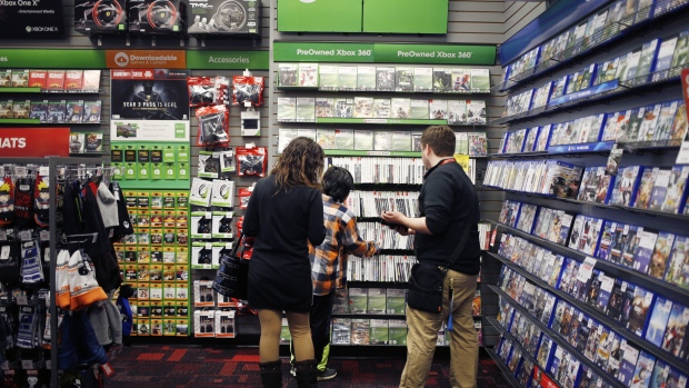 An employee assists customers shopping for Microsoft Corp. Xbox 360 video games inside a GameStop Corp. store in Louisville, Kentucky, U.S., on Thursday, March 15, 2018. GameStop Corp. is scheduled to release earnings figures on March 28. 
