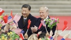 U.S. President Donald Trump, right, and Xi Jinping, China's president, greet attendees waving American and Chinese national flags during a welcome ceremony outside the Great Hall of the People in Beijing, China.