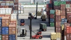 Trucks and forklifts operate as containers sit stacked at the Yangshan Deep Water Port in Shanghai, China, on Tuesday, July 10, 2018. China told companies to boost imports of goods from soybeans to seafood and automobiles from countries other than the U.S. after trade tensions between the world's two biggest economies escalated into a tariff war last week. 