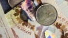 Canadian one dollar coins, also known as Loonies, and Canadian one hundred dollar banknotes are arranged for a photograph in Toronto, Ontario, Canada, on Wednesday, July 25, 2018. One of Prime Minister Justin Trudeau's envoys said the government would respond "proportionally" if the U.S. imposes tariffs on vehicles and parts, though Canada hasn't begun preparing any formal retaliatory package, two people familiar with the matter said. 