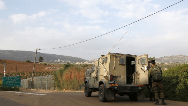 The northern Israeli town of Metula, shows Israeli soldiers standing outside a military vehicle near the border with Lebanon. - Israel's army said on December 4 it had detected Hezbollah "attack tunnels" infiltrating its territory from Lebanon and had launched an operation called "Northern Shield" to destroy them, a move likely to raise tensions with the Iran-backed group. Photographer: JALAA MAREY/AFP