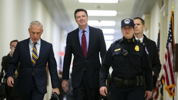 James Comey, former director of the Federal Bureau of Investigation (FBI), center, walks though the Rayburn House Office building to testify before the House Judiciary and House Oversight and Government Reform Committees joint investigation in Washington, D.C., U.S., on Friday, Dec. 7, 2018. Comey is expected to be asked about actions taken by the FBI in 2016, including a decision not to recommend criminal charges against Democrat Hillary Clinton for her use of a private email server, as well as the FBI's probe into potential coordination between Russia and Donald Trump's campaign. Photographer: Al Drago/Bloomberg
