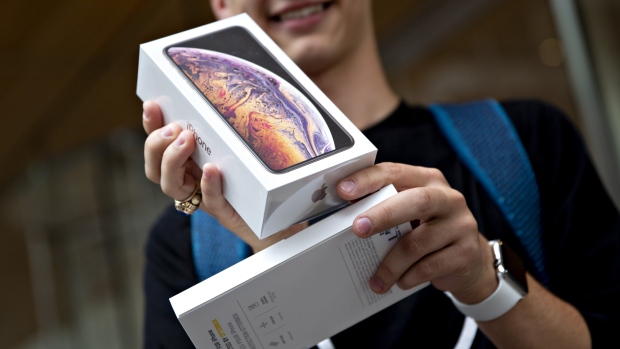 A customer displays an Apple Inc. iPhone XS Max box during a sales launch at a store in Chicago, Illinois, U.S., on Friday, Sept. 21, 2018.