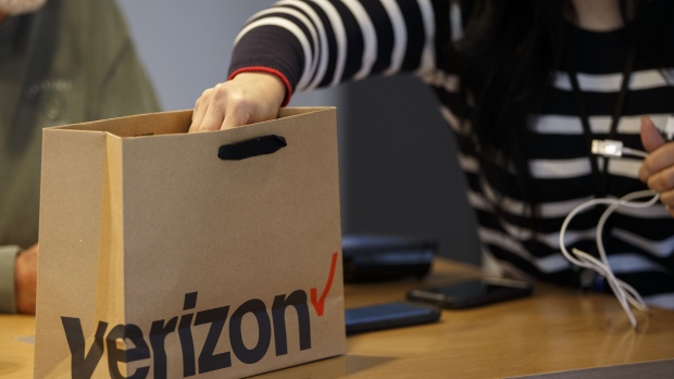 An employee places items into a shopping bag for a customer at a Verizon Communications Inc. store in Brea, California, U.S., on Monday, Jan. 22, 2018. Verizon is scheduled to release earnings figures on January 23. 